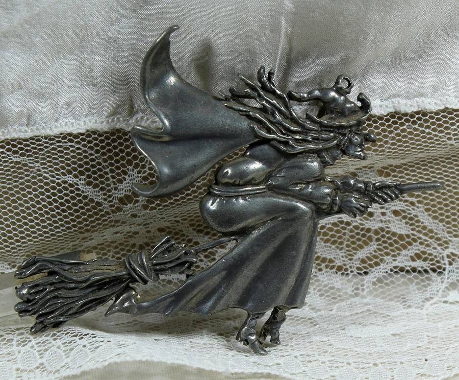 Large metal brooch of a witch with crystal