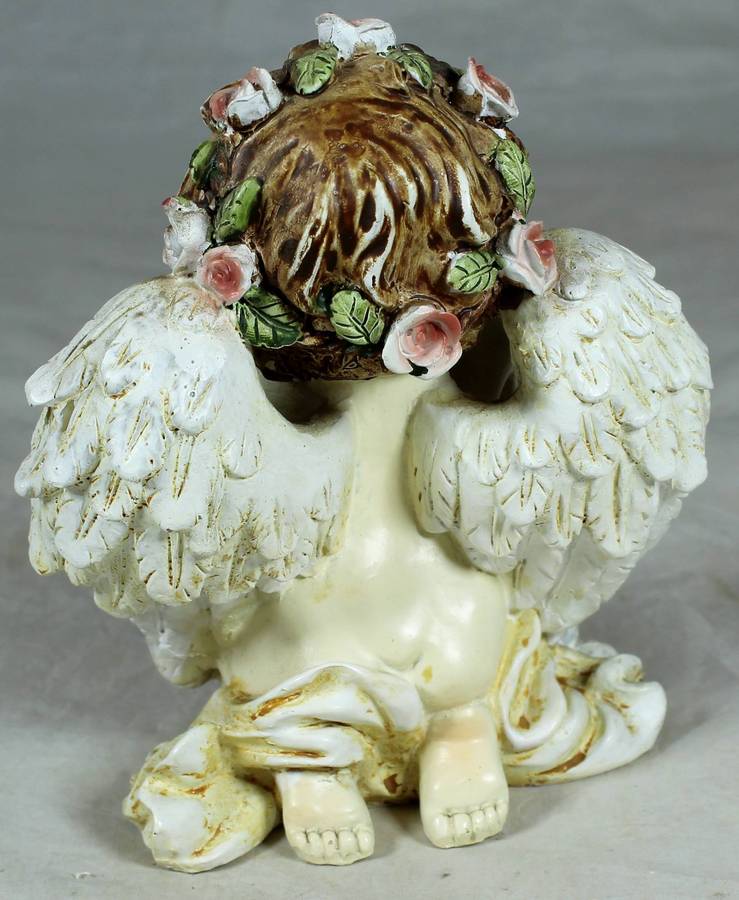 Kneeling baby angel with flowers in the hair