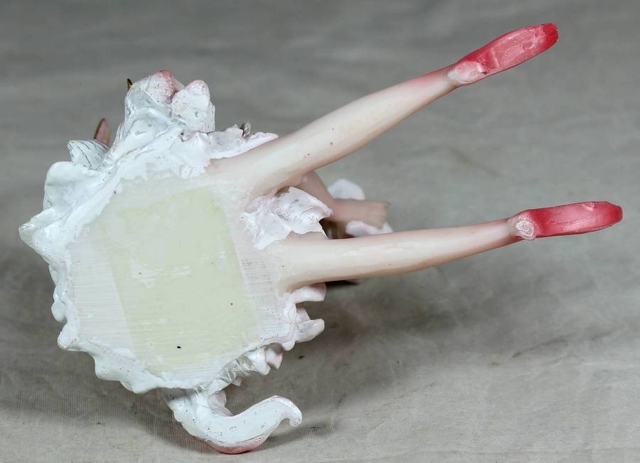 Seated ballerina in pink, holding a large flower