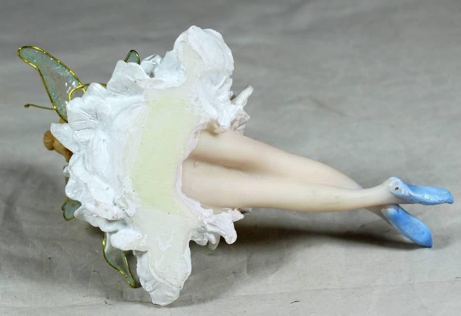 Seated ballerina in blue, holding a large flower