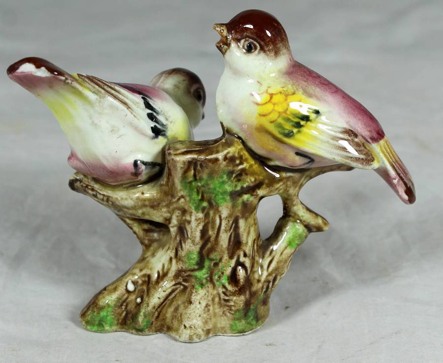 Pair of ceramic birds on a tree log