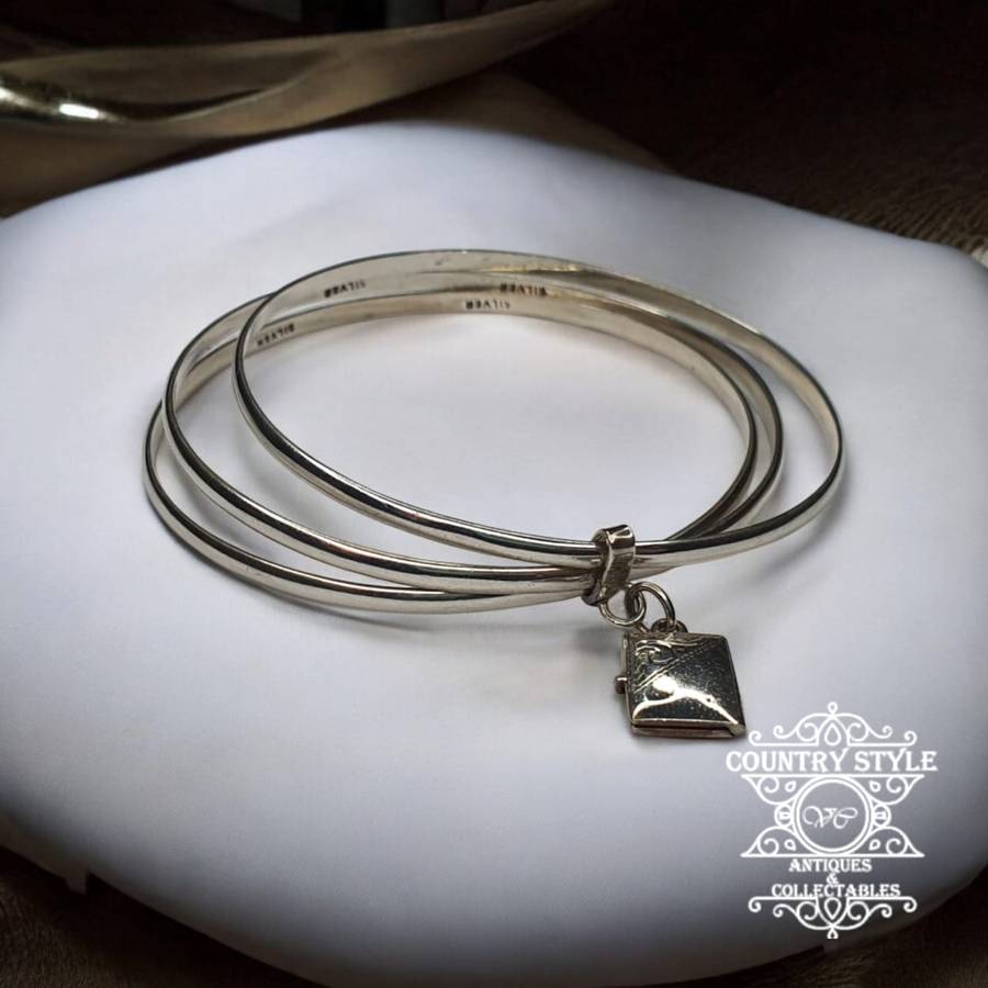 Trio of sterling silver bangles with a locket