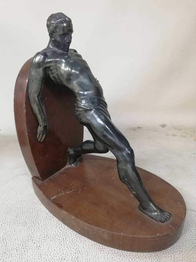 Vintage Bookend after R. Varmant, depicting a spelter leaning male athlete on a mahogany stand