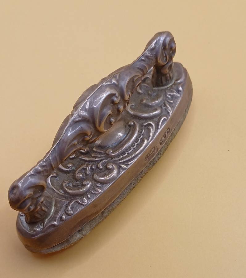 Marked silver nail buffer lion facing left