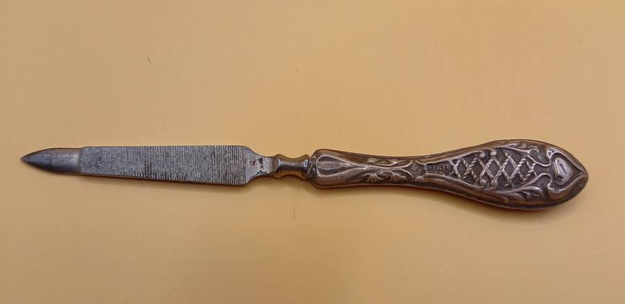 Marked silver nail file lion facing left