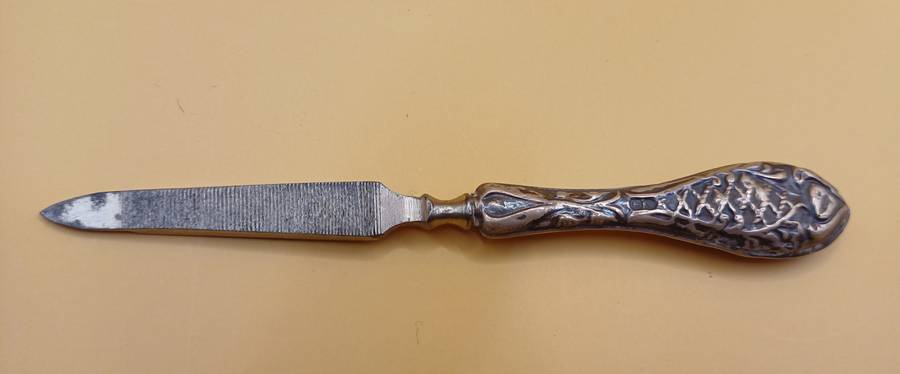 Marked silver nail file lion facing left