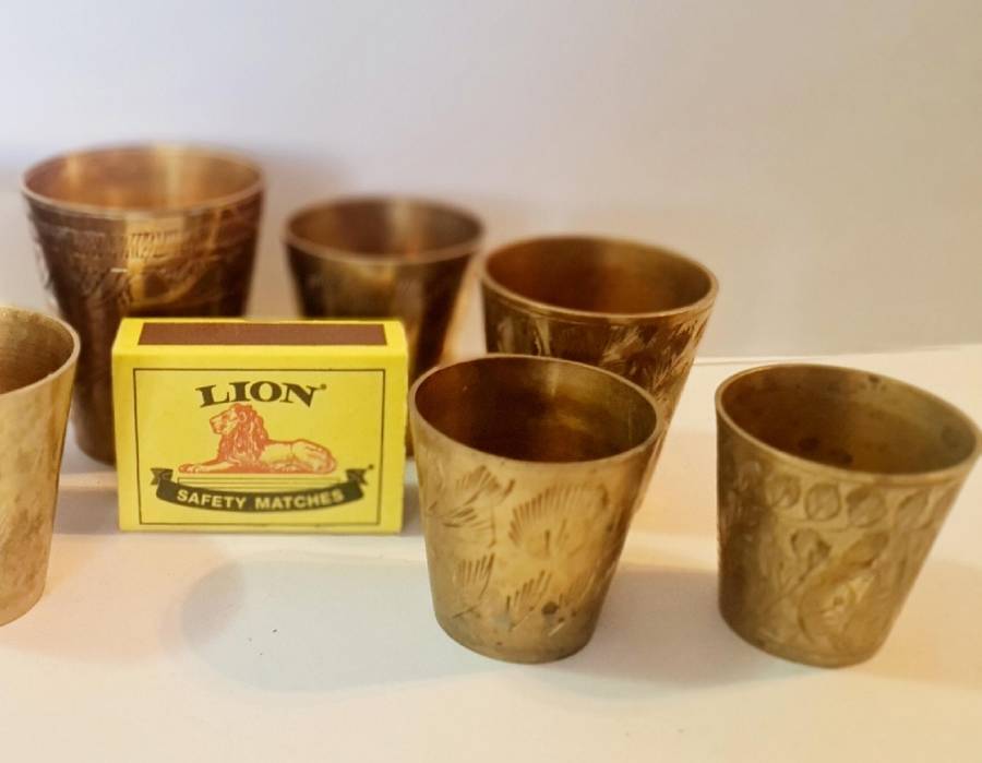 7 brass shot glasses. Various sizes