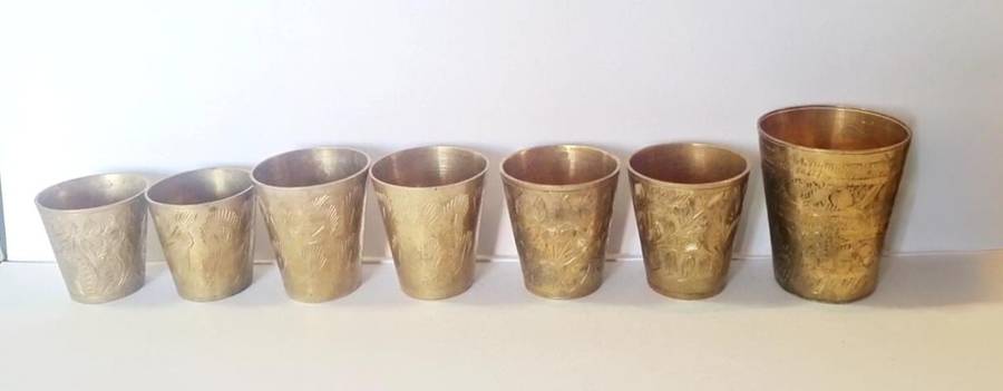 7 brass shot glasses. Various sizes