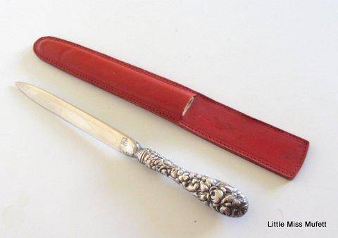 A fairly large sterling silver letter opener in a leather cover-- Sterling silver handle