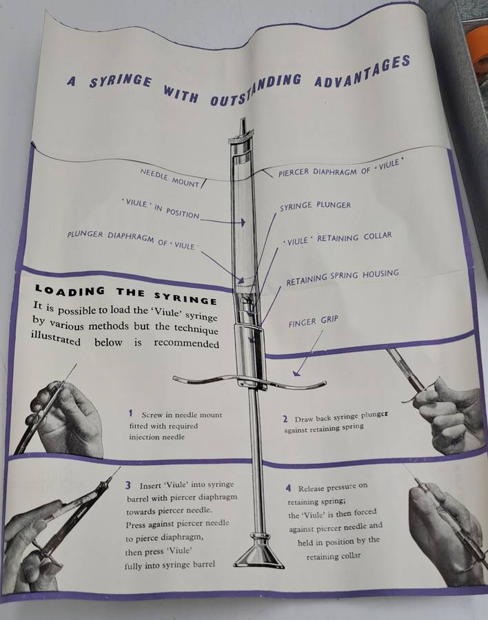 Boots viule syringe in a metal case with two glass containers with needles inside.