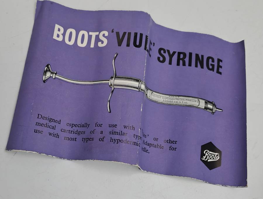 Boots viule syringe in a metal case with two glass containers with needles inside.