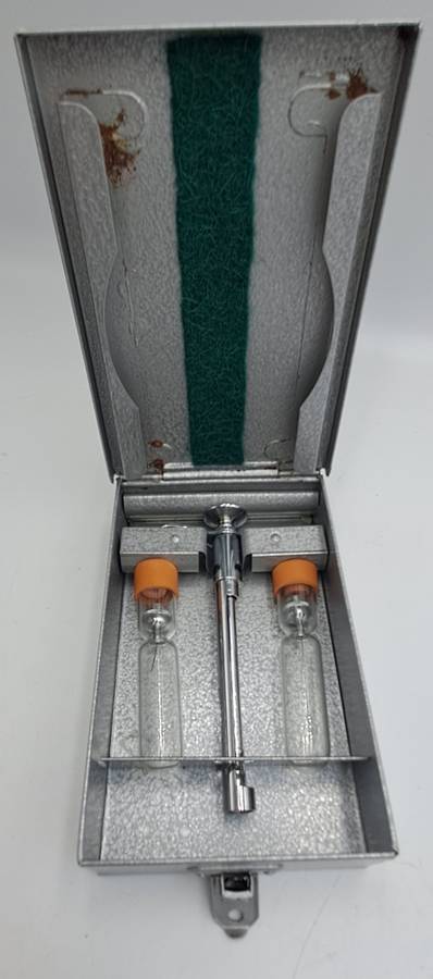 Boots viule syringe in a metal case with two glass containers with needles inside.