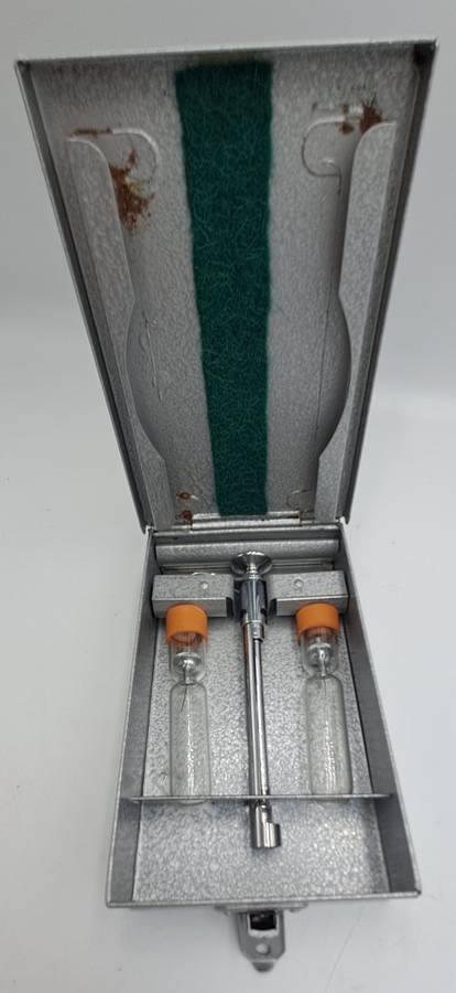 Boots viule syringe in a metal case with two glass containers with needles inside.