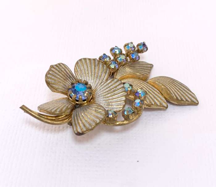 Brooch - Shiny blueish Stones With Fluted Flowers. Gold Colour #ML1037 R195.00 | Dimensions: 54mm...