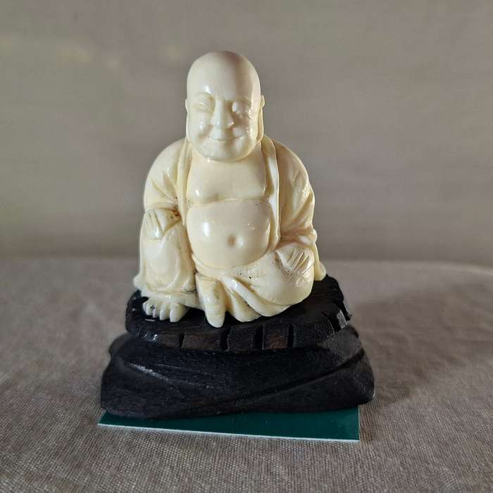 Carved buddha figurine on a wooden plinth 5.5 cms tall approx