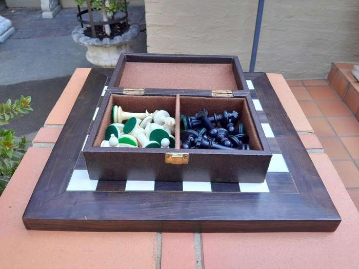 A 20th Century Hand Carved Ebony And Ivory Chess Set With Board And Leather Case