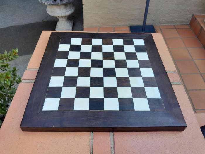 A 20th Century Hand Carved Ebony And Ivory Chess Set With Board And Leather Case