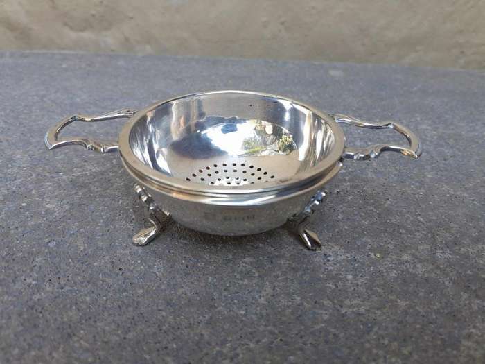 An English Elizabeth II Circa 1956 Georgian-style  Silver Tea Strainer  on Feet  Dimensions: ...