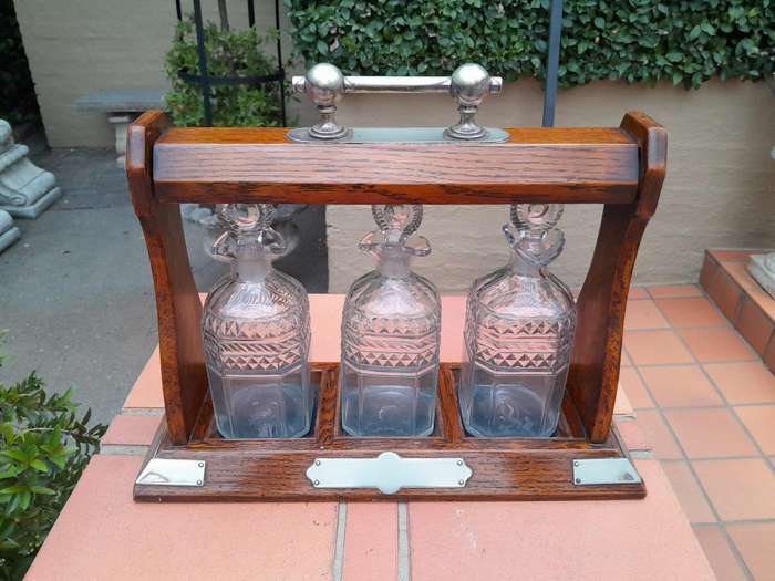 An English Oak Tantalus with 3 Glass Decanters & Metal Hardware
