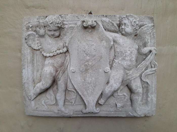 A Concrete Relief Plaque Sculpture With Putti (Cherubs) Holding A Crest