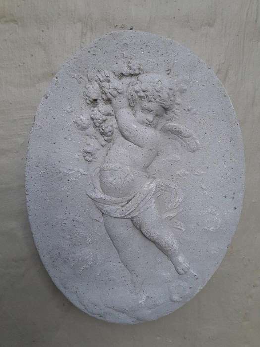 A Concrete Relief Oval Sculpture Of An Ornate Cherub Plaque