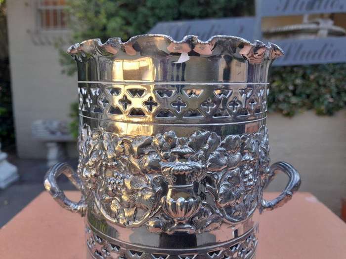 A Silver-Plate Wine Bottle Holder With Two Handles