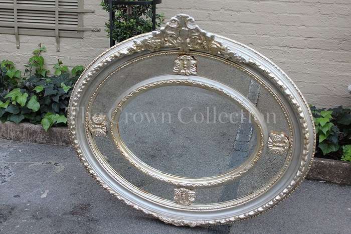 Ornate oval silver gilded mirror with crown