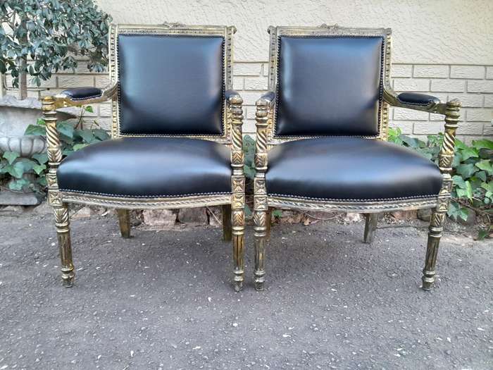 A Pair Of Louis XVI Style Carved And Gilded Armchairs Upholstered in Leather