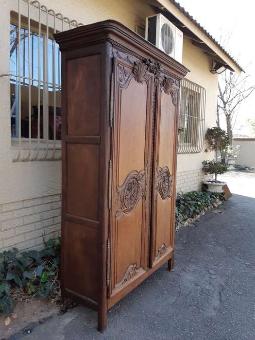 A French Provincial styled Ornately carved Armoire