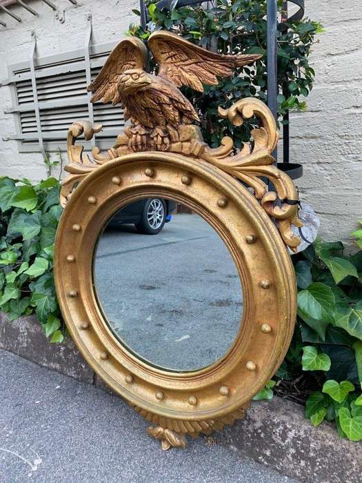 A circular framed 19thC style mirror with eagle crest