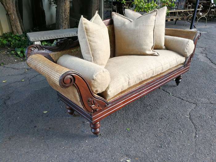 An Antique Victorian Carved Mahogany and Rattan Settee On Castors with Hessian Cushions and Bolsters