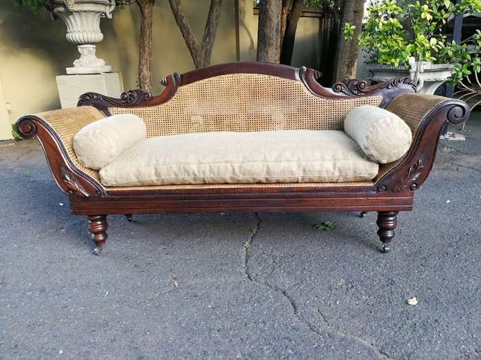 An Antique Victorian Carved Mahogany and Rattan Settee On Castors with Hessian Cushions and Bolsters