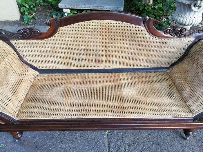 An Antique Victorian Carved Mahogany and Rattan Settee On Castors with Hessian Cushions and Bolsters