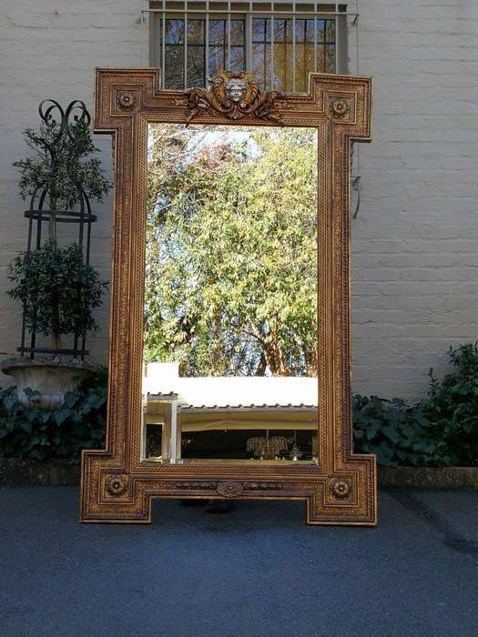 A Large Ornately Carved and Gilt Wood Bevelled Mirror