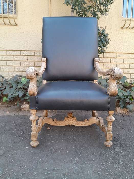 An Antique Ornately Carved Oak Throne Armchair Upholstered in Leather and in a Contemporary Bleac...