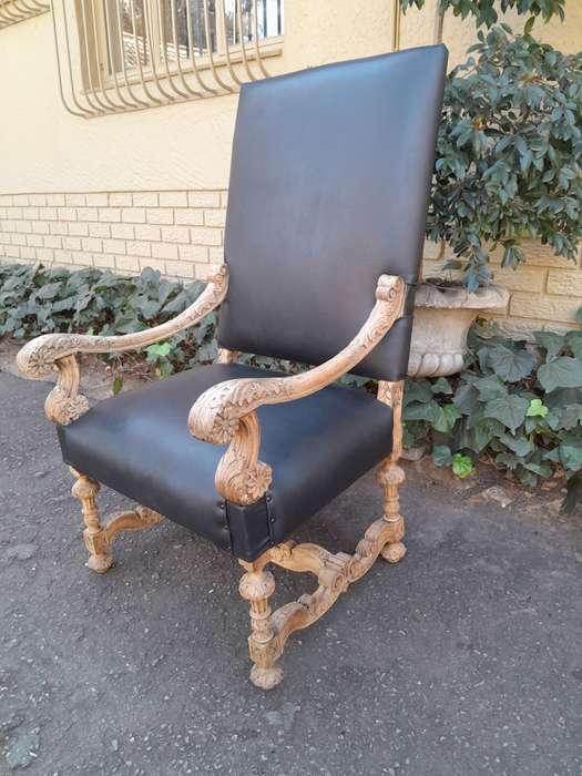 An Antique Ornately Carved Oak Throne Armchair Upholstered in Leather and in a Contemporary Bleac...