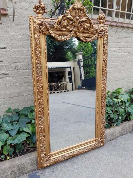 A French Style Ornately Carved And Gilded Bevelled Mirror