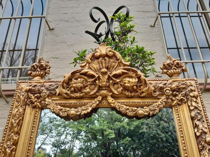 A French Style Ornately Carved And Gilded Bevelled Mirror