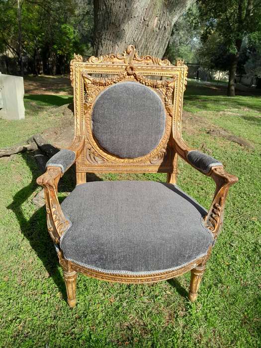 A 20th Century French Style Ornately Carved and Gilded Pair of Arm Chairs
