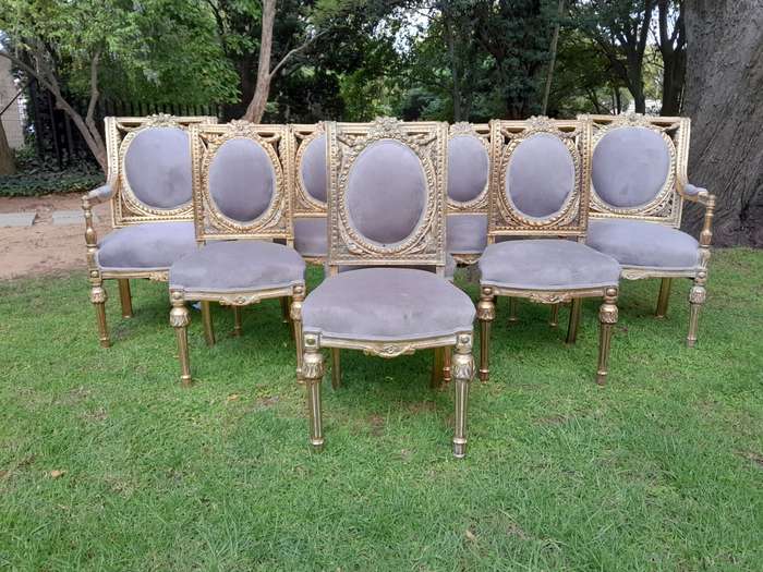 A Set of Eight French Style Ornately Carved and Gilded Dining Chairs (6 chairs and 2 Carvers)