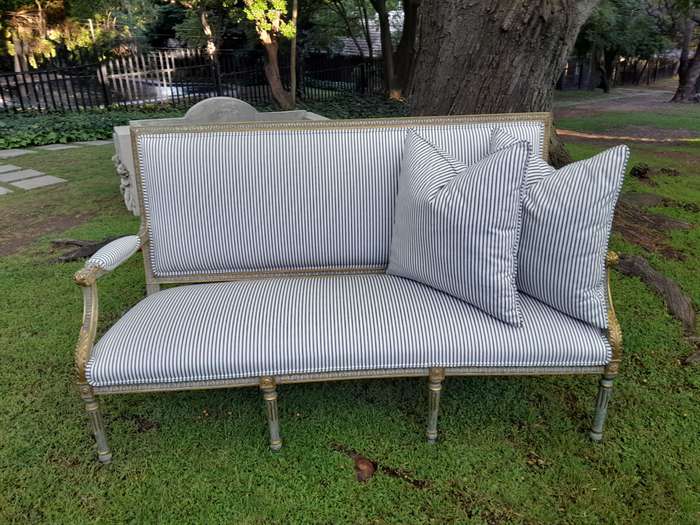 A 20th Century French  Style Carved and Hand Gilded Settee Upholstered in Ticking Fabric