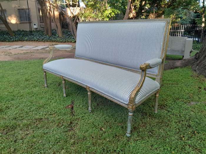 A 20th Century French  Style Carved and Hand Gilded Settee Upholstered in Ticking Fabric