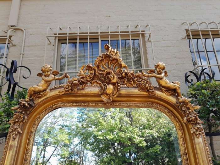 A French Style Ornately Carved And Gilded Bevelled Mirror