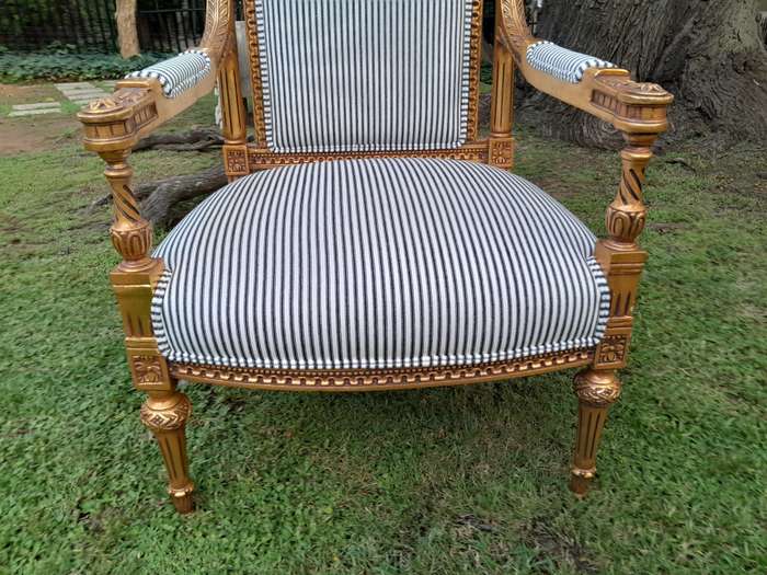 A Pair of French Rococo Style Ornately Carved Giltwood Arm Chairs Upholstered in a Contemporary T...