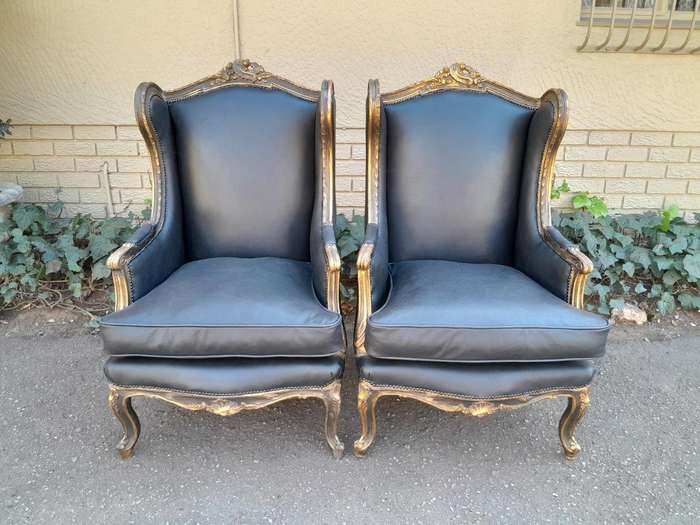 A Circa 1900s French Style Pair Of Carved Giltwood Wingback Chairs Upholstered In Leather