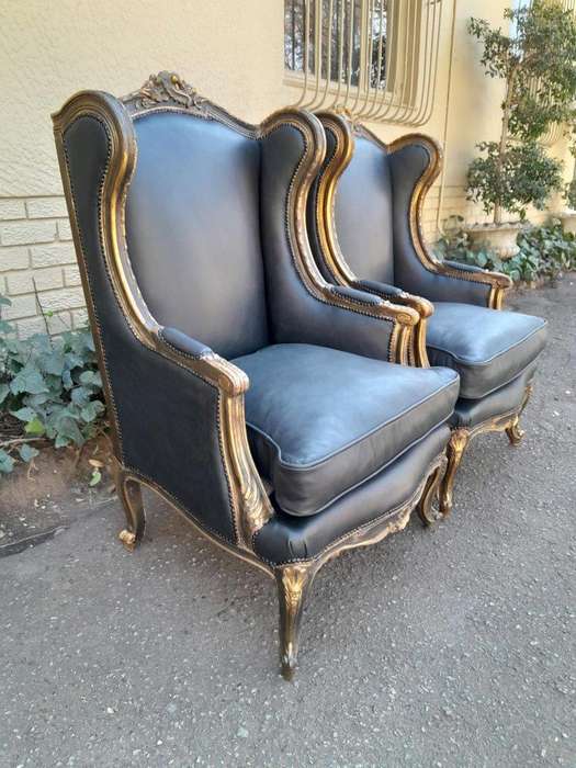 A Circa 1900s French Style Pair Of Carved Giltwood Wingback Chairs Upholstered In Leather