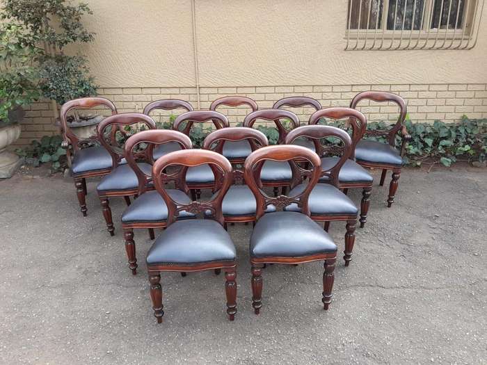 A 20th Century Set of Fourteen (14) Victorian Style Mahogany Bustle Back Chairs Upholstered in Le...