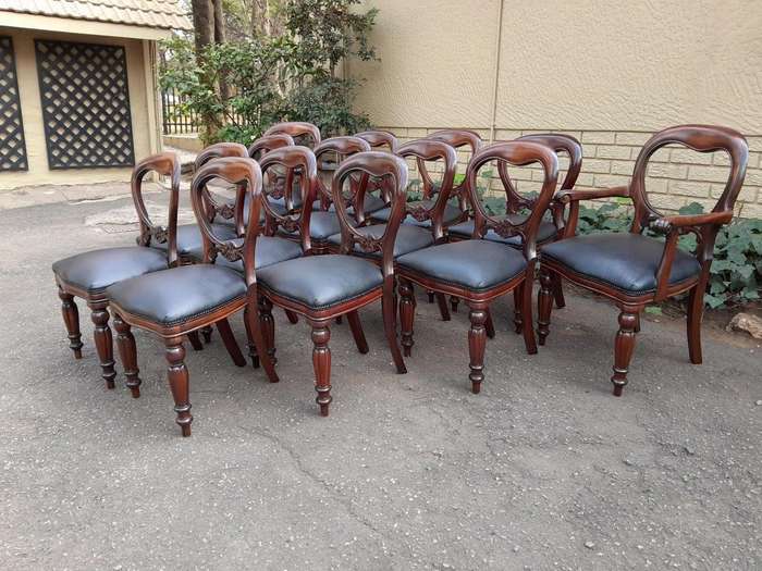 A 20th Century Set of Fourteen (14) Victorian Style Mahogany Bustle Back Chairs Upholstered in Le...