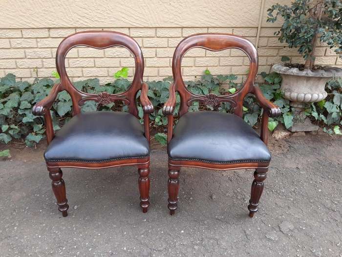 A 20th Century Set of Fourteen (14) Victorian Style Mahogany Bustle Back Chairs Upholstered in Le...