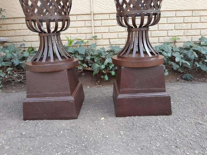 A 20th Century Pair of Decorative Wrought Iron Urns on Plinths